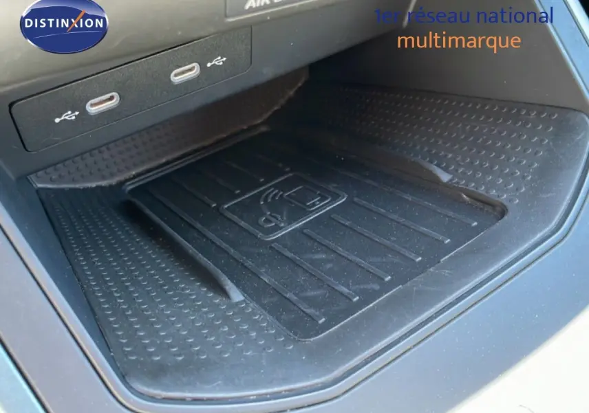 Gros plan sur la zone de recharge sans fil et ports USB du SEAT Arona blanc toit noir, intérieur noir.