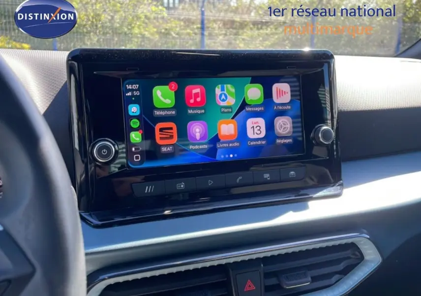 Vue intérieure centrée sur l’écran tactile multimédia du tableau de bord du SEAT Arona 2025 blanc toit noir.