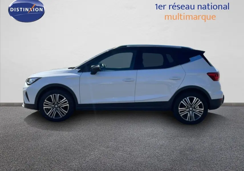 Vue de profil côté gauche du SEAT Arona blanc avec toit noir, roues alliage et lignes modernes, sur fond neutre.