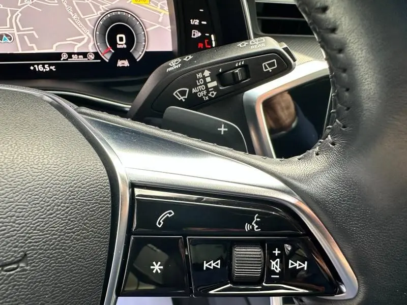 Gros plan sur le volant cuir multifonction et commandes vocales de l'Audi A6 Avant noir métal 2019.