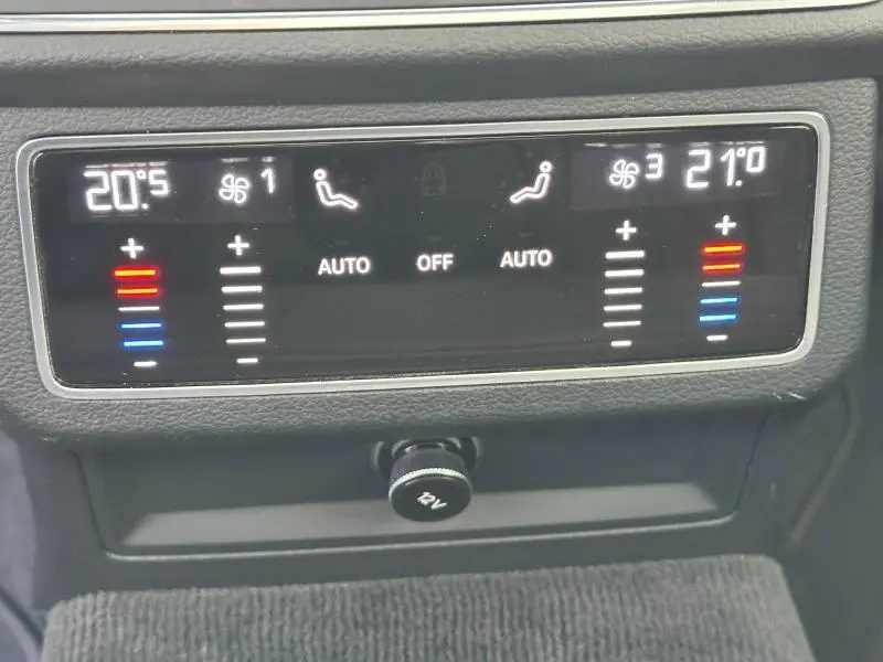 Panneau de contrôle de la climatisation bi-zone de l'Audi A6 Avant 45 TDI noir métal, affichage digital et réglages tactiles.