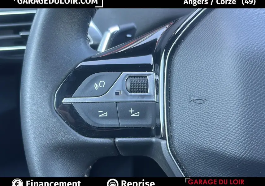 Gros plan sur les commandes gauche du volant en cuir noir du Peugeot 3008 Bleu Celebes, finition Allure Pack.