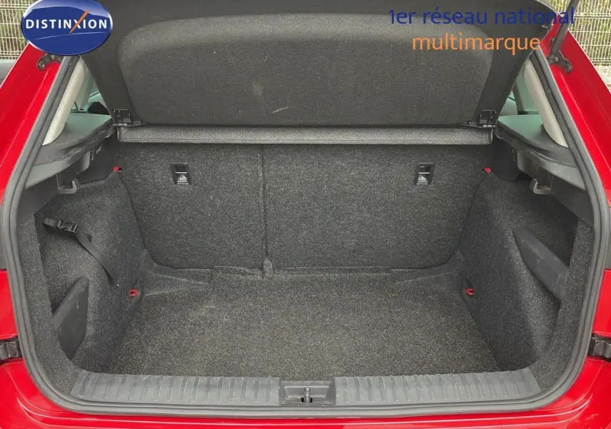 Coffre ouvert d'une Skoda Kamiq rouge Velvet Metal, vue arrière montrant l'espace de chargement vide et doublé de tissu gris.