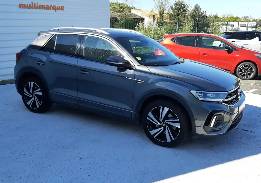 Volkswagen T-Roc gris Indium en vue 3/4 avant côté gauche, avec jantes alliage et toit panoramique.