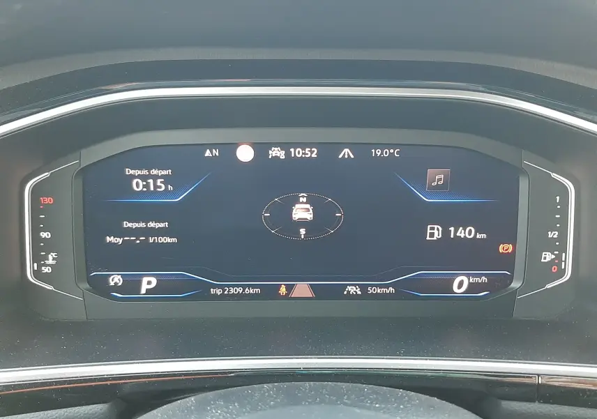 Vue rapprochée du tableau de bord numérique du Volkswagen T-Roc 2.0 TDI 150CH R-LINE 2024 affichant la vitesse, la boussole et l'autonomie.