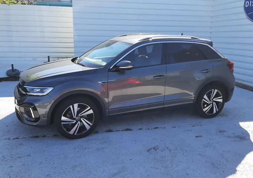 Volkswagen T-Roc 2.0 TDI R-Line gris Indium vu de profil côté gauche, avec jantes alliage bicolores et toit noir.