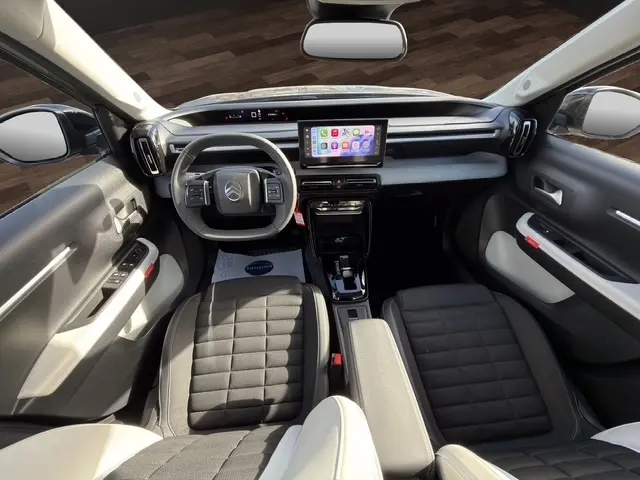 Intérieur vue avant de la Citroën C3 Aircross hybride gris foncé, tableau de bord moderne avec écran tactile central.