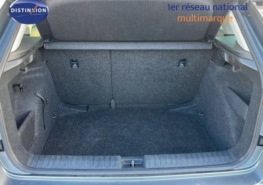 Coffre ouvert du Skoda Kamiq gris graphite métal 2024, vue intérieure montrant l'espace de chargement vide et les finitions en tissu gris.