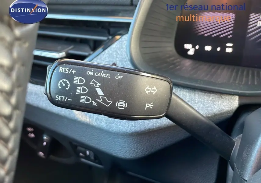 Gros plan sur la commande de régulateur de vitesse dans l'habitacle gris du Skoda Kamiq 2024.