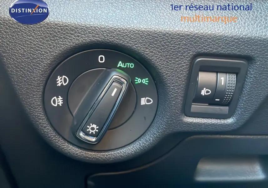 Détail du bouton de commande des phares sur tableau de bord noir du Skoda Kamiq gris graphite 2024.