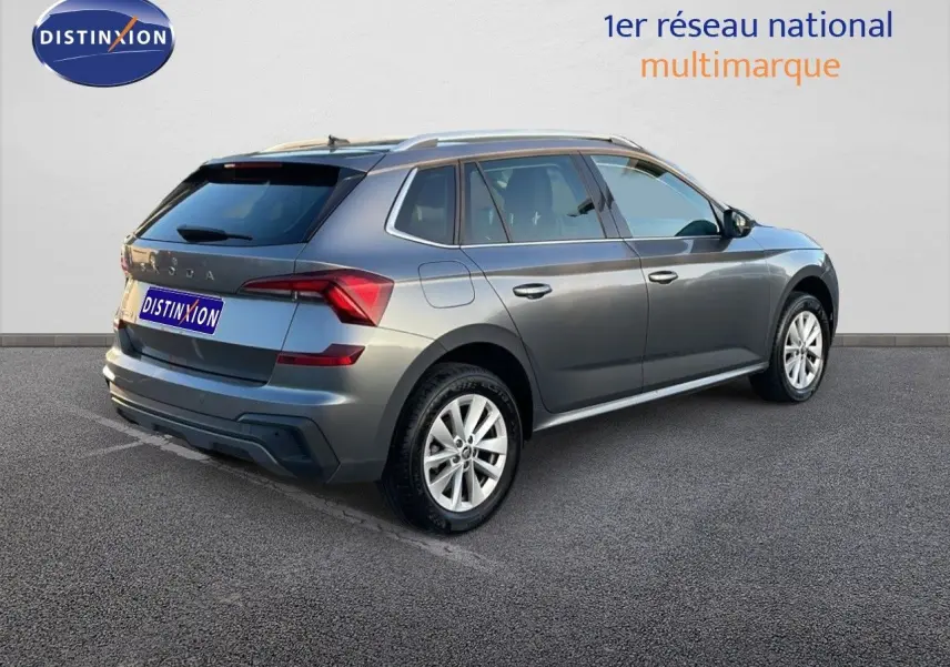 Vue 3/4 arrière droite d'un Skoda Kamiq gris graphite métal 2024 avec jantes alliage et toit surélevé.