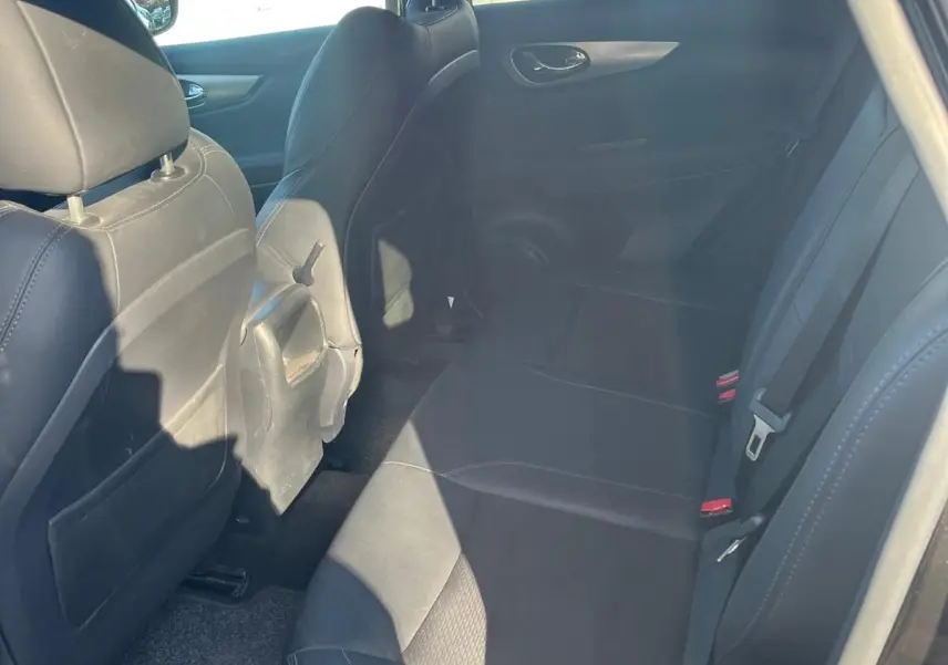 Vue intérieure côté droit des sièges arrière en cuir noir du Nissan Qashqai II PH2 2017 avec ceintures visibles.