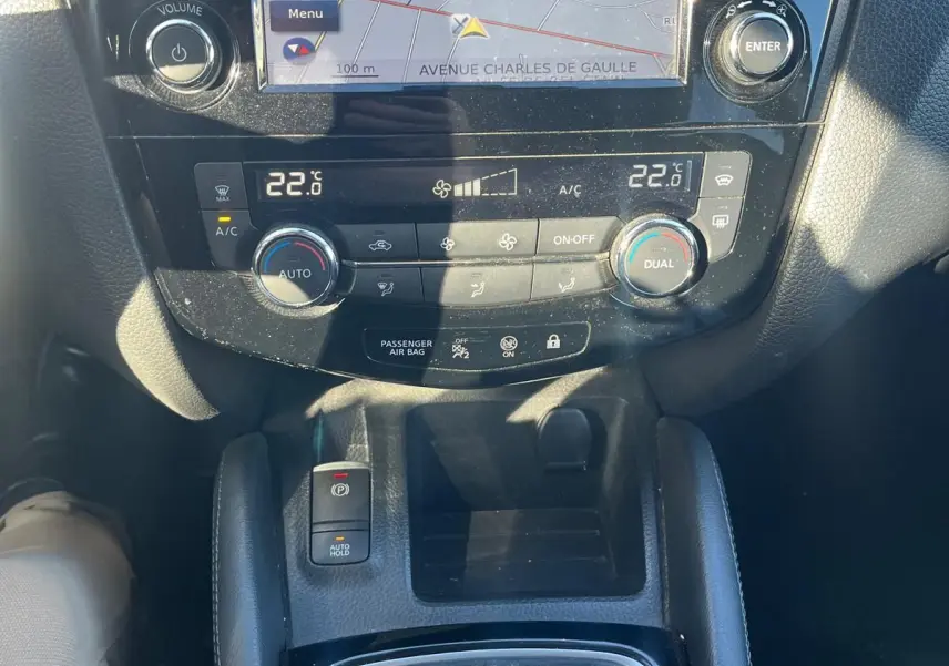 Vue rapprochée de la console centrale du Nissan Qashqai noir, avec écran tactile GPS et levier de vitesse manuel.