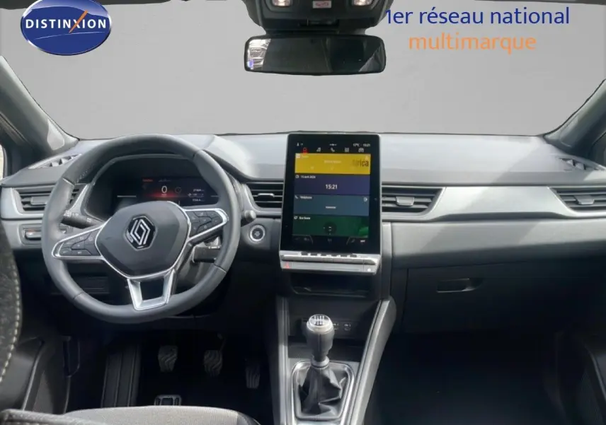 Vue intérieure avant du Renault Captur 2025, tableau de bord moderne avec écran tactile vertical et volant multifonction.
