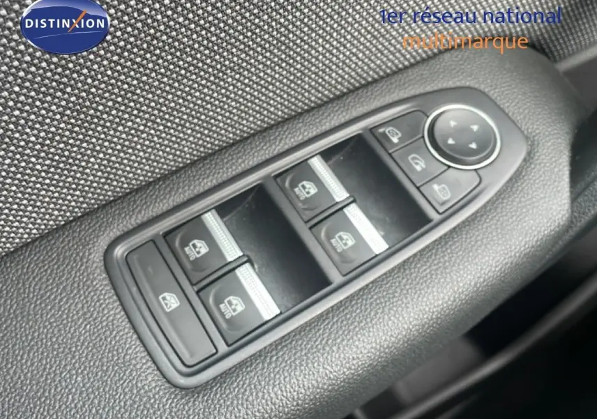 Gros plan sur les commandes de lève-vitres et réglage des rétroviseurs côté conducteur du Renault Captur gris Cassiopée métal.