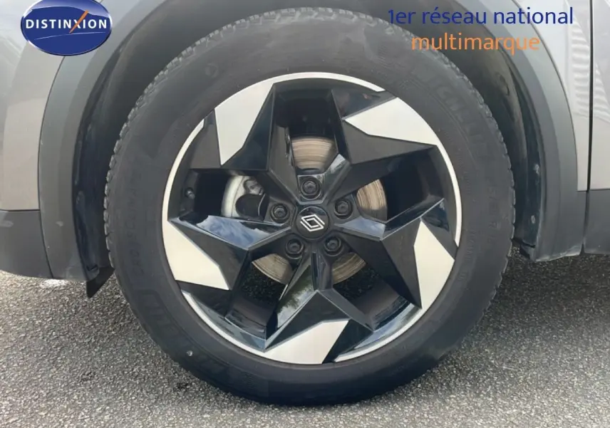 Gros plan sur la roue avant gauche du Renault Captur gris Cassiopée métal avec jante noire et argentée en étoile.