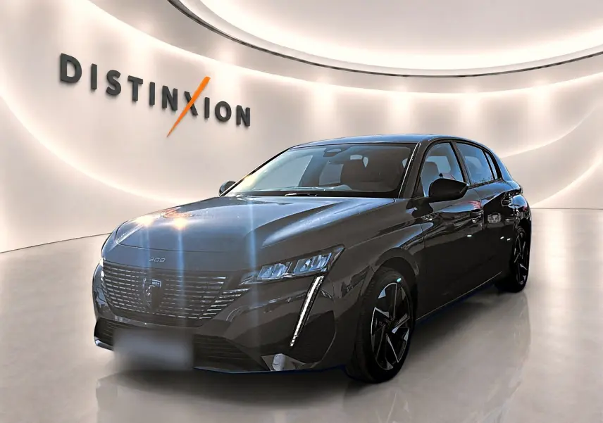 Vue 3/4 avant droite d'une Peugeot 308 gris selenium avec phares LED et jantes alliage noires dans un showroom lumineux.