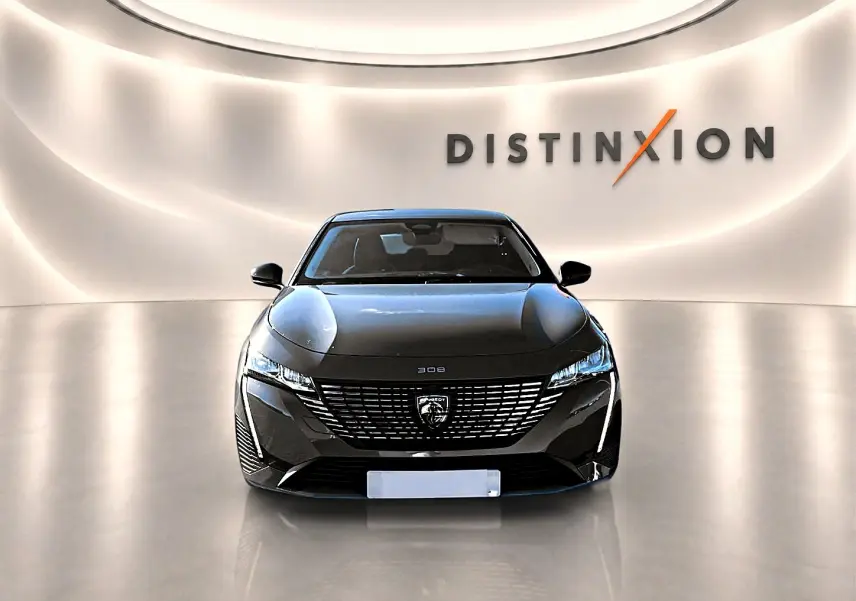 Vue avant d'une Peugeot 308 gris selenium avec calandre distinctive et phares LED dans un showroom lumineux.