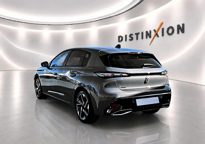 Vue 3/4 arrière droite d'une Peugeot 308 gris selenium avec jantes alu dans un showroom lumineux.