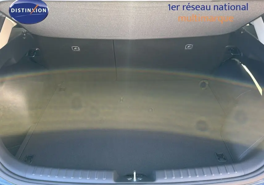 Coffre ouvert du Kia Niro 2025 bleu minéral métal, vue plongeante montrant l'espace de chargement vide et propre.