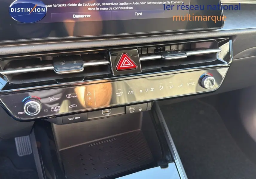 Tableau de bord et console centrale du Kia Niro hybride rechargeable 2025, avec commandes climatisation et port USB visibles.