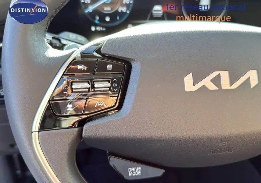 Gros plan sur le volant cuir noir du Kia Niro 2025 avec commandes intégrées et logo KIA visible au centre.