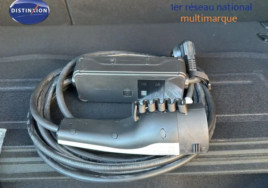 Câble de recharge noir enroulé dans le coffre d'une Kia Niro hybride rechargeable bleu minéral.