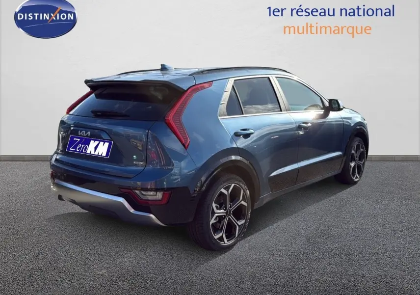 KIA Niro hybride rechargeable bleu minéral métal vu en 3/4 arrière droit, avec feux arrière en forme de boomerang et jantes bi-ton.