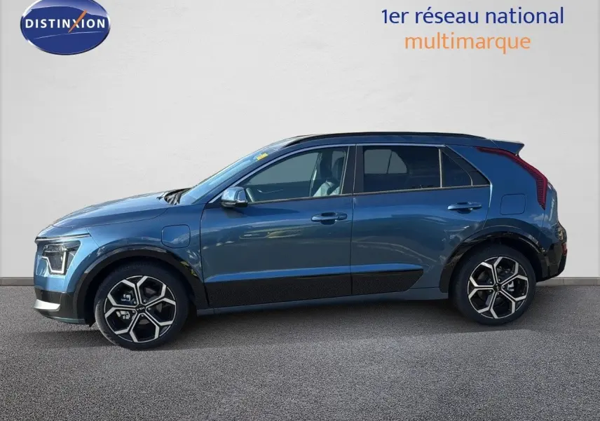 Vue latérale droite d'un KIA NIRO hybride rechargeable bleu minéral métal avec jantes alliage bi-ton et toit noir.