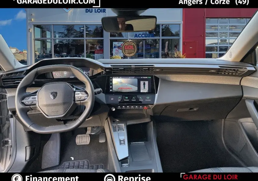 Intérieur avant de la Peugeot 308 gris Artense 2024, tableau de bord moderne avec écran tactile et volant compact.