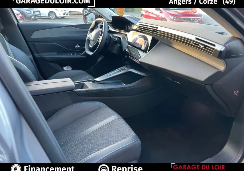 Intérieur avant gauche de la Peugeot 308 2024 gris Artense, avec tableau de bord numérique et sellerie tri-matières.