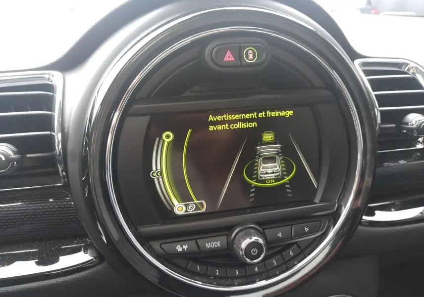 Écran central rond du tableau de bord MINI Clubman 2017 affichant l'alerte de freinage avant collision.