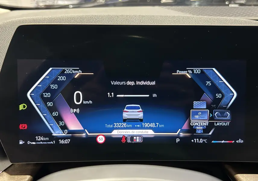 Affichage numérique du tableau de bord BMW Série 2 Active Tourer 218i, montrant la consommation et la vitesse à 0 km/h.