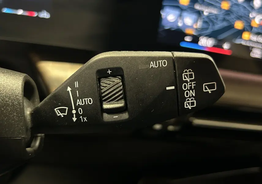 Gros plan sur la commande de l'essuie-glace automatique à l'intérieur d'une BMW Série 2 Active Tourer blanche, modèle 218i 2022.