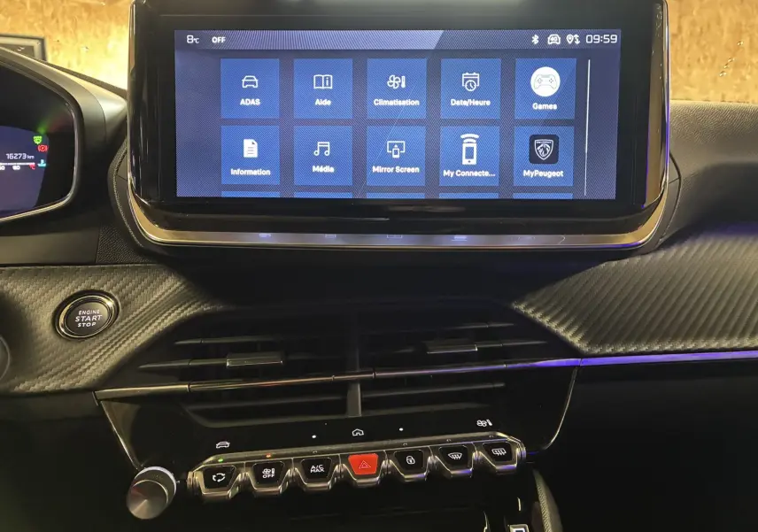 Vue rapprochée de l'écran tactile central et des commandes du tableau de bord noir du Peugeot 2008 hybride 2025.
