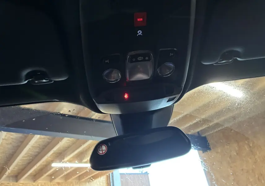 Vue intérieure du plafond avant de la Peugeot 2008 bleu 2025, montrant les commandes d'éclairage et le rétroviseur central.