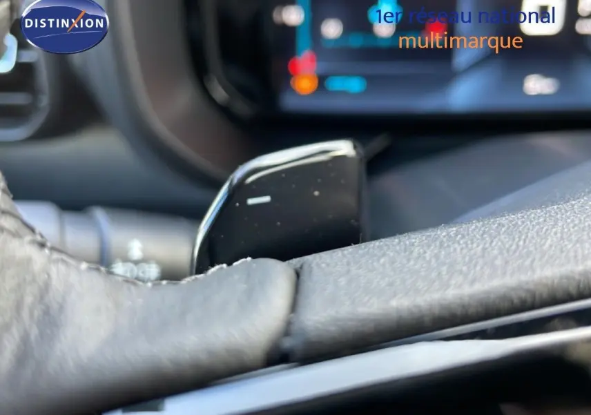 Gros plan sur la palette de changement de vitesse noire du volant du Citroën Berlingo blanc glacier, intérieur moderne.