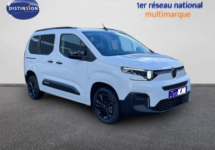 Vue 3/4 avant droite du Citroën Berlingo blanc glacier avec jantes noires et protections latérales noires.