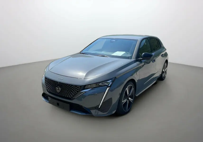 Peugeot 308 2025 gris selenium vue 3/4 avant droit avec calandre noire et phares LED distinctifs.