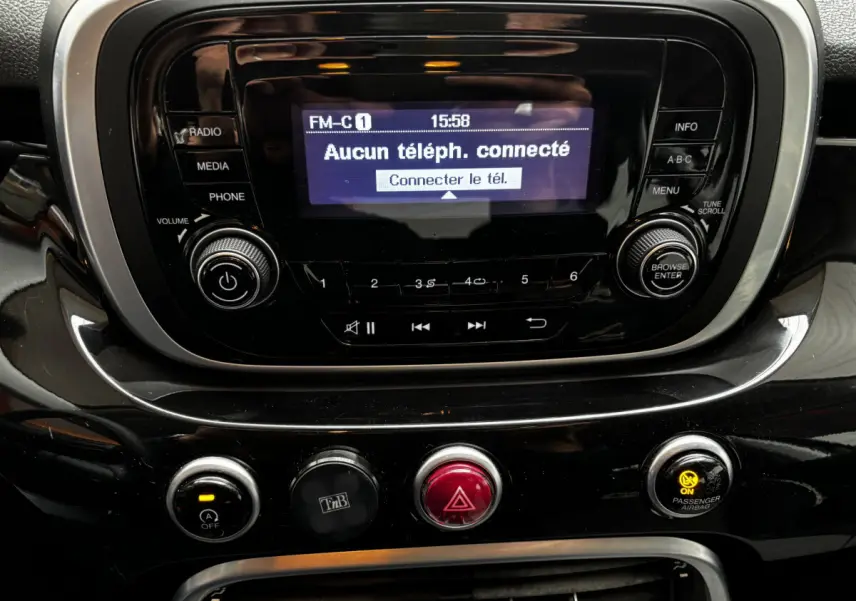 Gros plan sur la console centrale noire du Fiat 500X 2018, affichant l’écran radio et les commandes de climatisation.