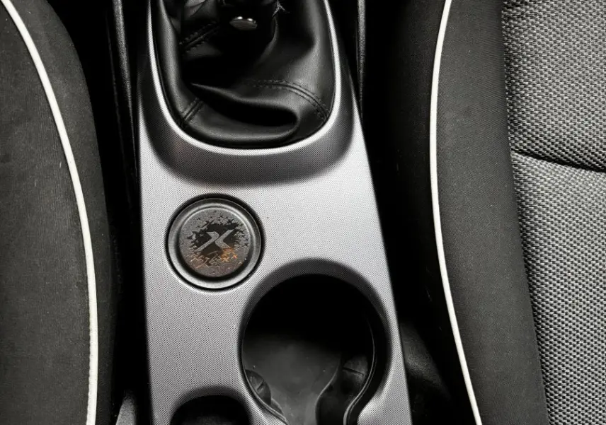 Vue plongeante sur la console centrale noire de la Fiat 500X 2018, avec levier de vitesse manuel et porte-gobelets.