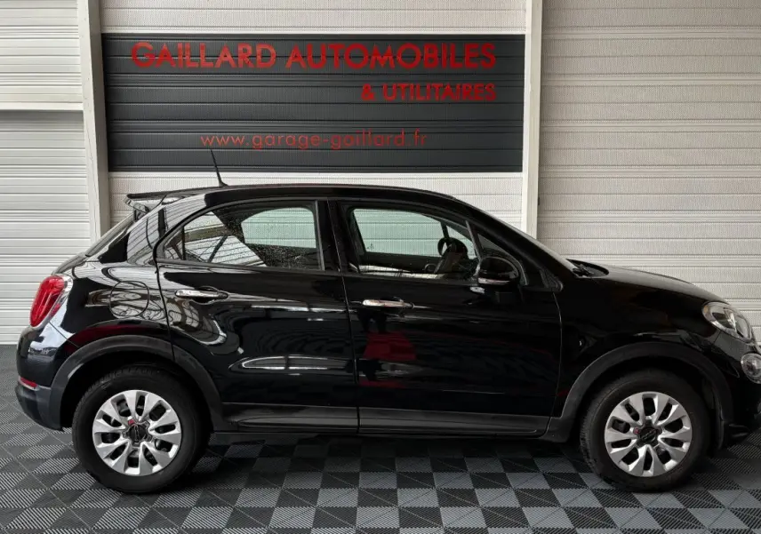 Profil droit de la Fiat 500X noire 2018, compacte avec jantes argentées et poignées de porte chromées.