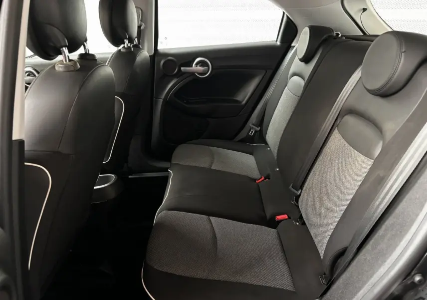 Vue intérieure arrière droite des sièges tissu noir et gris de la Fiat 500X 2018, avec appuie-têtes ronds.