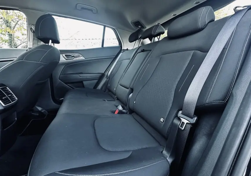 Banquette arrière noire vue côté droit du Kia Sportage 2023 avec ceintures et appuie-têtes intégrés.