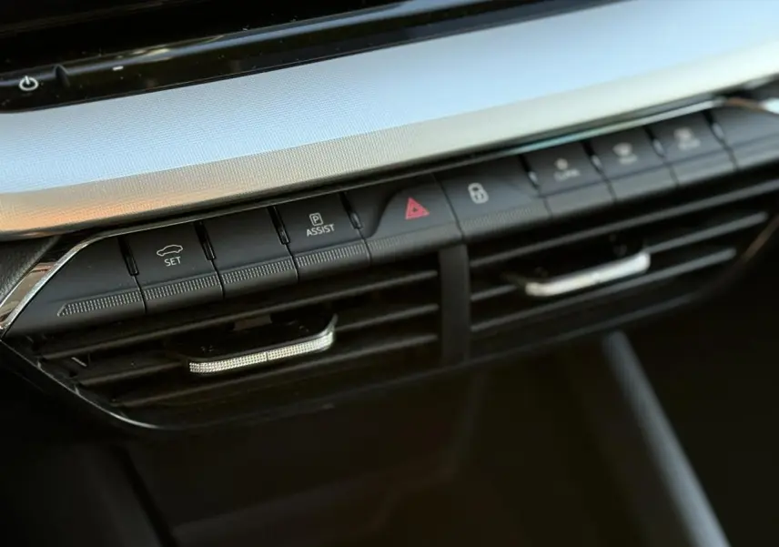 Gros plan sur la console centrale noire de la Skoda Octavia Combi 2022, mettant en valeur les boutons de commande et les aérateurs.