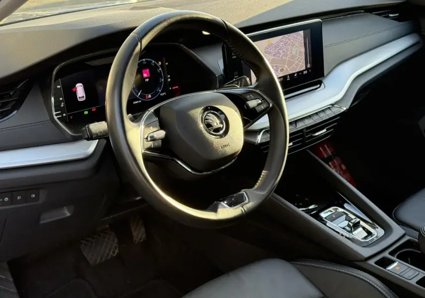 Intérieur de la Skoda Octavia Combi 2022 vu côté conducteur, volant cuir et tableau de bord numérique avec navigation.