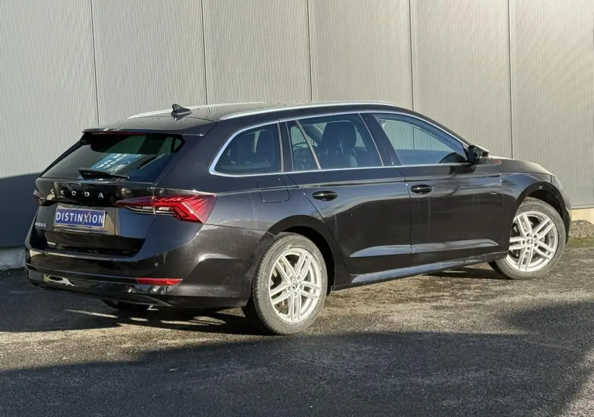 SKODA OCTAVIA COMBI noir vue 3/4 arrière droit, hayon électrique et jantes alliage 17 pouces visibles.