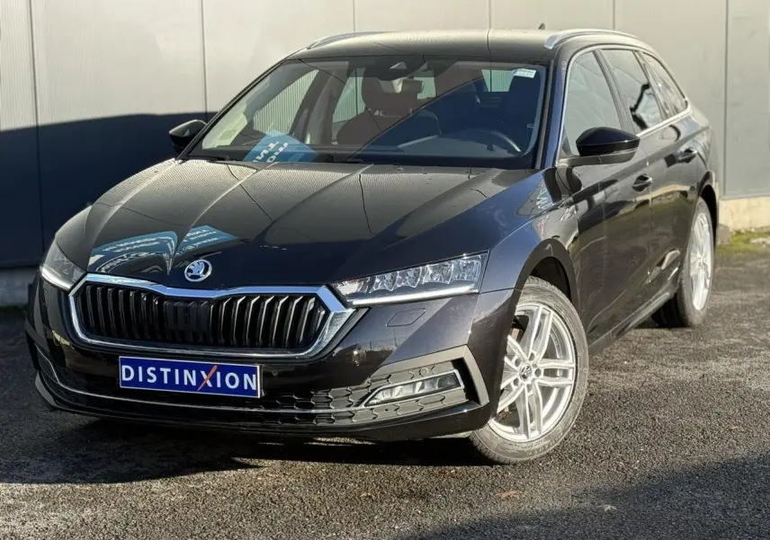 Vue 3/4 avant droite d'une Skoda Octavia Combi noire avec calandre chromée et jantes alliage 17 pouces.