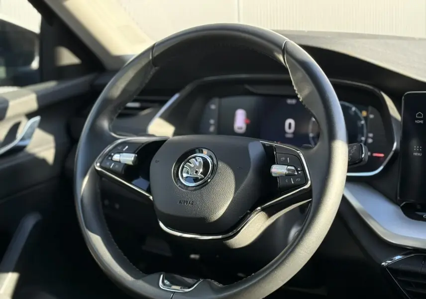 Volant cuir noir de Skoda Octavia Combi 2022 avec commandes intégrées et tableau de bord numérique en arrière-plan.