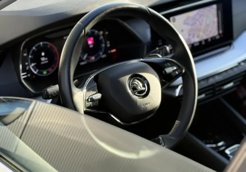 Vue rapprochée du volant noir et du tableau de bord digital de la Skoda Octavia Combi 2022, avec écran de navigation visible.